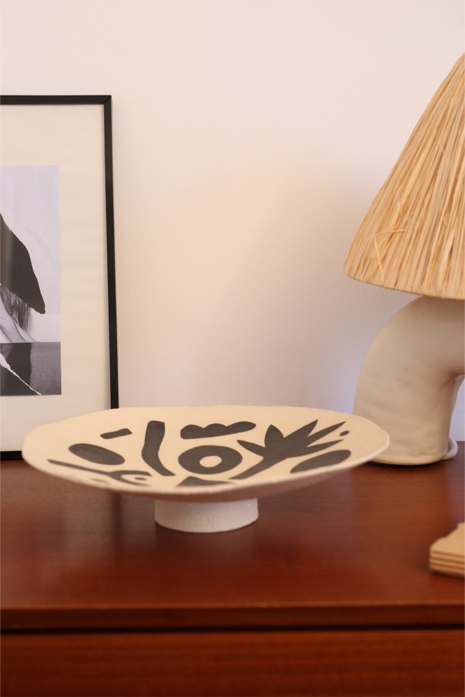 Coupe à pied en grès avec un dessins de feuille vigitale en noir fabriquée de façon artisanale à Paris