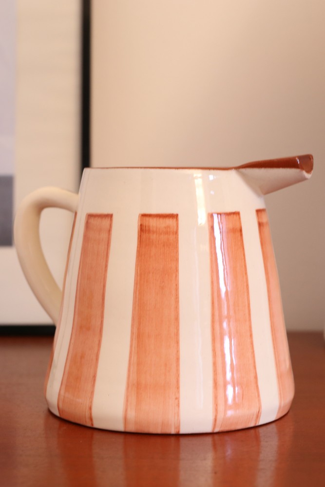 Kan in Portugal handgemaakte keramische kan met strepen in het wit en terracotta.