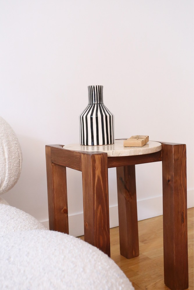 Mesa auxiliar de travertino beige y madera diseñada artesanalmente en Marruecos.