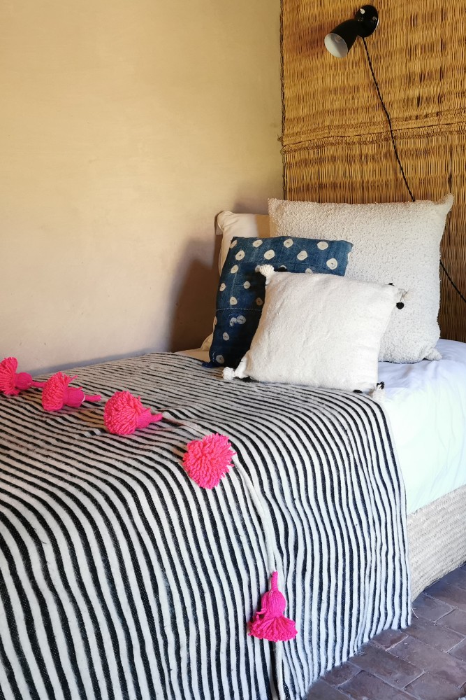 Plaid noir et blanc à pompons rose en laine confectionné à la main au Maroc